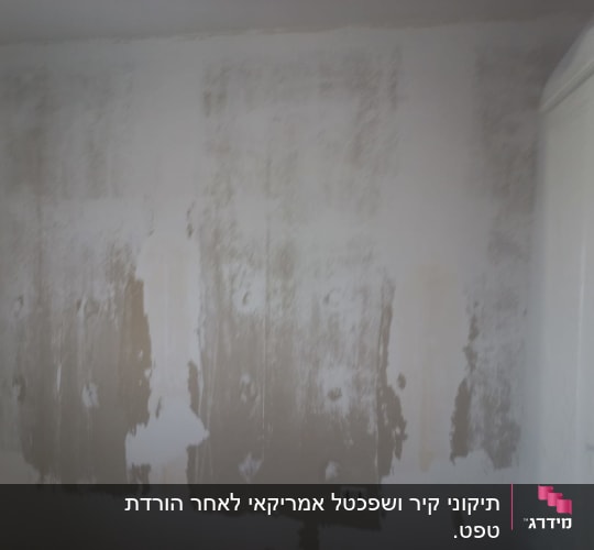 קיר עם שכבת צבע מתקלפת ותיקונים